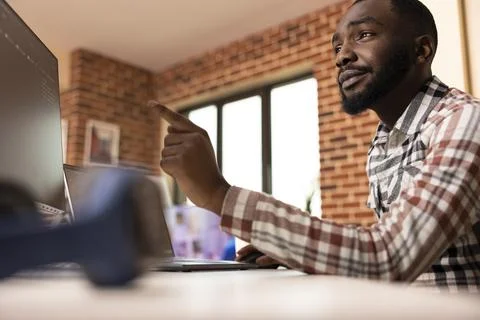Black freelancer developing software using multiple device screens 库存照片