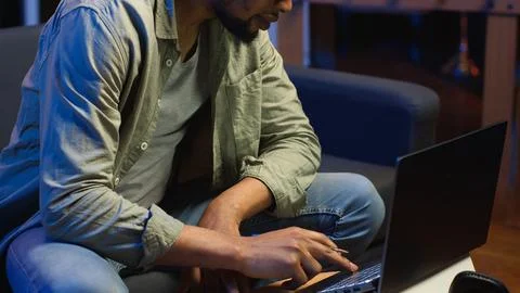 Black freelancer taking notes on his textbook in order to solve his tasks Stock Photos