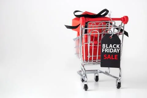 Black friday background with red box, black bow in shopping cart Stock Photos