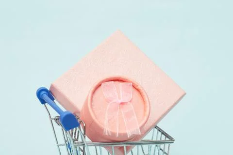 Black friday concept, gift boxes with shopping trolley on blue pastel background Stock Photos