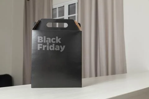 Black Friday gift box on the table with black packaging with writing in dark  Fotos Stock