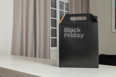 Black Friday gift box on the table with black packaging with writing in dark  Stockfoto's
