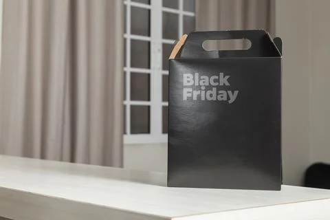 Black Friday gift box on the table with black packaging with writing in dark  Fotos Stock