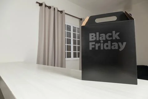 Black Friday gift box on the table with black packaging with writing in dark  Fotos Stock