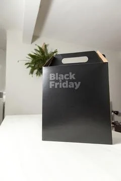 Black Friday gift box on the table with black packaging with writing in dark  Fotos Stock