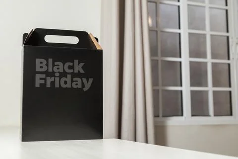 Black Friday gift box on the table with black packaging with writing in dark  Stock-Fotos