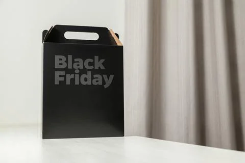 Black Friday gift box on the table with black packaging with writing in dark  Fotos Stock