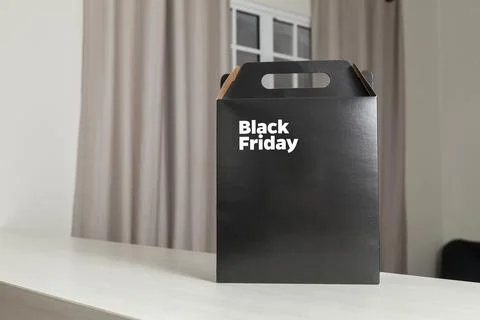 Black Friday gift box on the table with black packaging with writing in dark  Fotos Stock