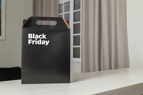 Black Friday gift box on the table with black packaging with writing in dark  Fotos Stock