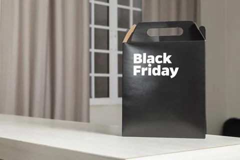 Black Friday gift box on the table with black packaging with writing in dark  Fotos Stock