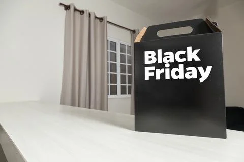 Black Friday gift box on the table with black packaging with writing in dark  Stock-Fotos