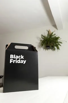 Black Friday gift box on the table with black packaging with writing in dark  Stockfoto's