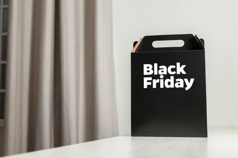 Black Friday gift box on the table with black packaging with writing in dark  Stockfoto's