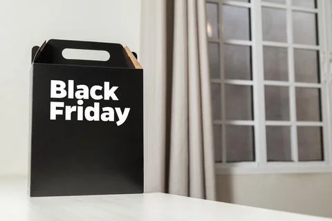 Black Friday gift box on the table with black packaging with writing in dark  Fotos Stock