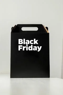 Black Friday gift box on the table with black packaging with writing in dark  Stockfoto's