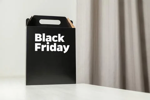 Black Friday gift box on the table with black packaging with writing in dark  Фото