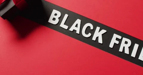Black friday text in white on black stripe and black gift box with red ribbon, 動画素材 337159275