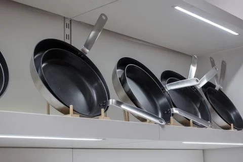 Black fried pans on the wall Stock Photos