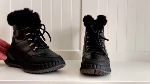 Black Fur-Lined Winter Boots on White Background, Hand Interaction Vídeo Stock 321518257