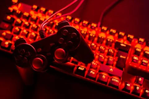 Black gamepad is lying on a pc keyboard Stock Photos