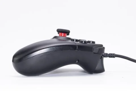 Black Gaming Controller with Red Joystick on White Background, Side View, C.. Foto stock