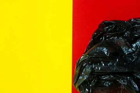 Black garbage bag roll on red background Stock Photos