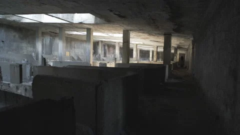 A black ghost of a woman wanders in a large hall of an old abandoned factory. Video stock 112946930