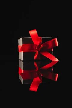  Black gift box with ribbon and copy space over black background. Cyber mo... Stock Photos