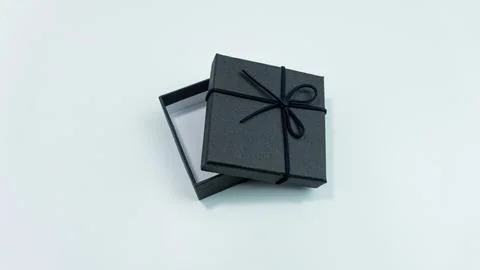 Black gift box with texture with black ribbon isolated on white background... Stock Photos