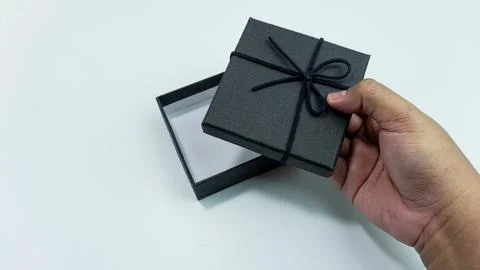 Black gift box with texture with black ribbon isolated on white background... Stock Photos