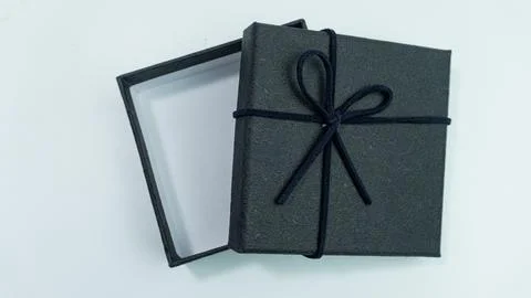 Black gift box with texture with black ribbon isolated on white background... Stock Photos