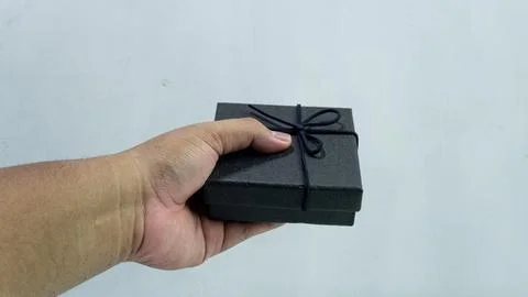 Black gift box with texture with black ribbon isolated on white background... Stock Photos