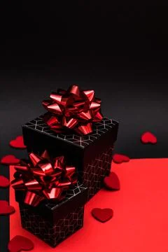 Black gift boxes with geometric pattern, decorated with red bows Stock Photos