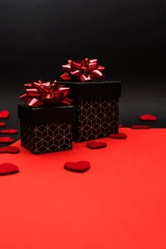Black gift boxes with geometric pattern, decorated with red bows Stock Photos
