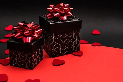Black gift boxes with geometric pattern, decorated with red bows Foto stock