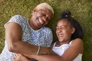 Black Girl And Grandmother Lying On Grass, Overhead Close Up Stock Photos
