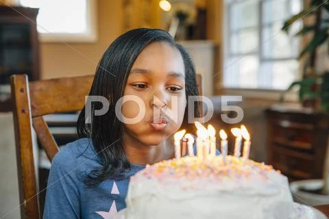 Black Girl Blowing Out Candles On Birthday Cake