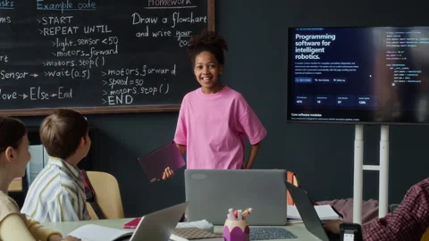Black Girl Explaining Robotics Programming to Classmates in School Stock Footage 339196140