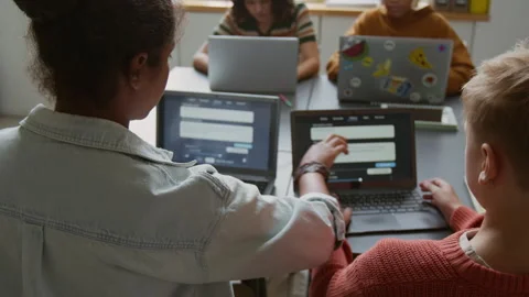 Black Girl Helping Classmate with Task on AI Prompting at Programming Lesson Stock Footage 318712816