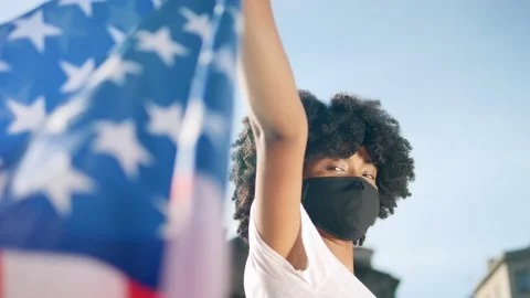 Black girl holding an USA flag outdoors Stock Footage