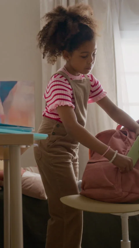 Black Girl Packing Notebooks into Backpack for School Day Stock Footage 337564798