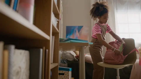 Black Girl Packing Notebooks into Backpack and Getting Ready for School Stock Footage 337566470