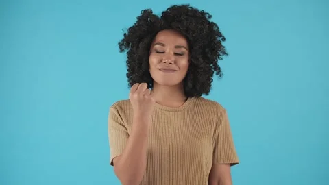 A black girl is standing in front of the camera and waving her fist. A young Stock Footage 240725965
