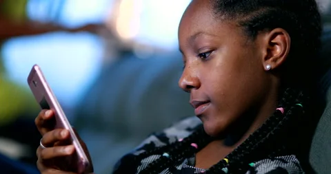 Black girl using smartphone device. Candid African teen looking at cellphone  Stock Footage 145317786
