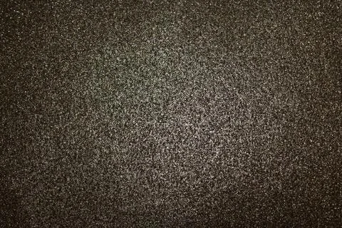 Black glittery background with light in the centre Stock Photos