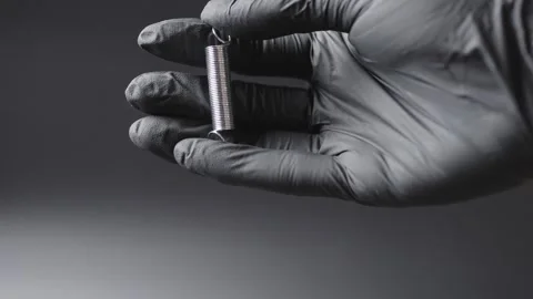 A black glove on the hands , a spring is shown in the hands and how it bends in  Stock Footage 304536567