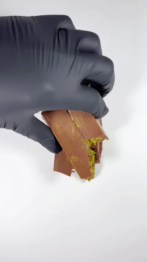 A black-gloved hand takes a slice of Dubai chocolate Stock Footage 293643431
