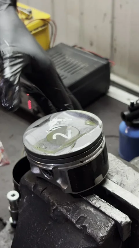 Black gloved hand touching car piston held in metal vise. Stock Footage 332065025