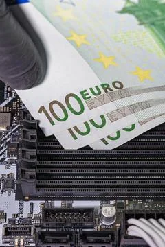 Black-gloved hands inserting 100 euro banknotes into empty RAM slots on a m.. Stock Photos