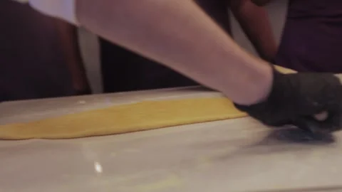 Black gloved hands rolling out pasta dough, pizza dough. Stock Footage 300028344